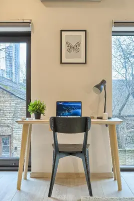 a desk with a chair and a laptop on it at Business-class apartments 2 x Free Parking x SELF CHECK IN 24x7 in Vilnius