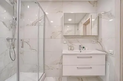 a white bathroom with a shower and a sink at Business-class apartments 2 x Free Parking x SELF CHECK IN 24x7 in Vilnius