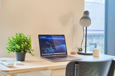 a laptop computer sitting on a desk with a lamp at Business-class apartments 2 x Free Parking x SELF CHECK IN 24x7 in Vilnius