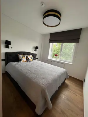 a bedroom with a large bed and a window at Apartamentai JOLA in Vilkaviškis