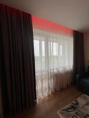 a room with a window with curtains and a couch at Apartamentai JOLA in Vilkaviškis
