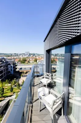 a balcony with white chairs and a view of the city at Brand New Central Panorama (SELF CHECK-IN) in Vilnius