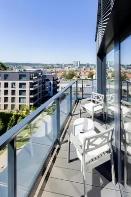 a balcony with chairs and tables on a building at Brand New Central Panorama (SELF CHECK-IN) in Vilnius