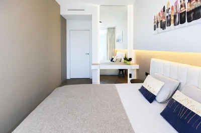 a bedroom with a white bed and a desk at Brand New Central Panorama (SELF CHECK-IN) in Vilnius