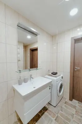 a bathroom with a washing machine and a sink at New Modern studio apartment next to the city centre in Vilnius