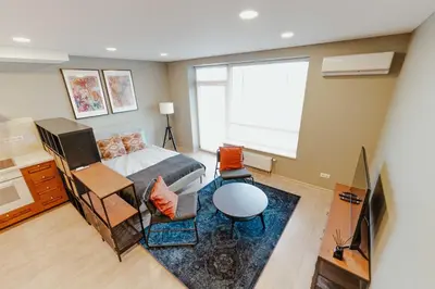 a living room with a couch and a tv at New Modern studio apartment next to the city centre in Vilnius