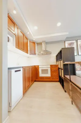 a kitchen with wooden cabinets and white appliances at New Modern studio apartment next to the city centre in Vilnius