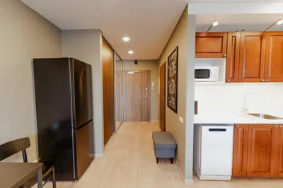 a kitchen with a black refrigerator and a table at New Modern studio apartment next to the city centre in Vilnius