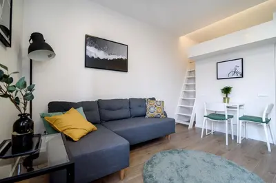 a living room with a blue couch and a table at Modern 1BR / Near Gates of Dawn / Special Offer in Vilnius