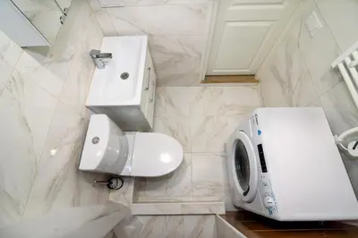 a bathroom with a sink and a washing machine at Modern 1BR / Near Gates of Dawn / Special Offer in Vilnius
