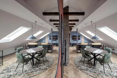 an office with tables and chairs and skylights at Cozy Penthouse in Vilnius