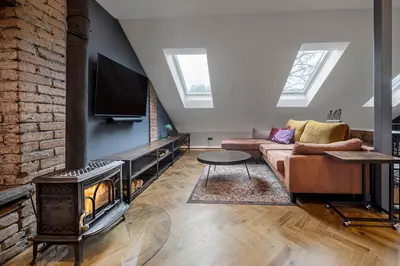 a living room with a couch and a fireplace at Cozy Penthouse in Vilnius