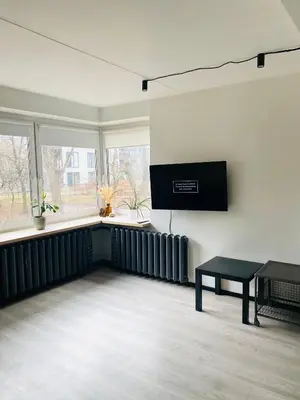 a room with a radiator and a table and windows at Modern & Cozy Gem - Spacious Central Retreat with private entrance in Vilnius