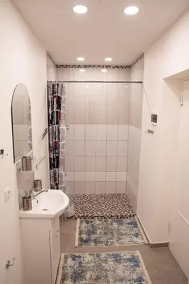 a white bathroom with a shower and a sink at Svečių namai Aurėja in Kėdainiai