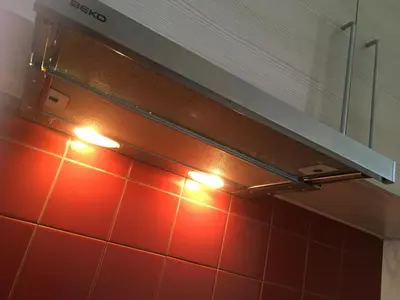 a stove top oven with lights on a tiled wall at Natalex MicroLofts in Vilnius