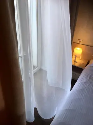 a bedroom with a white bed and a window at Natalex MicroLofts in Vilnius