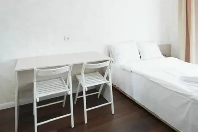 a bed with a desk and two chairs in a room at Natalex MicroLofts in Vilnius