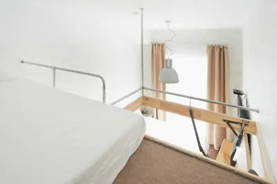 a bedroom with a white bed and a window at Natalex MicroLofts in Vilnius