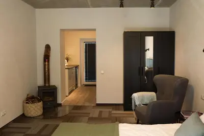 a room with a bed and a chair and a fireplace at Svedresort in Švedriškė