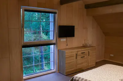 a bedroom with two windows and a bed and a television at Svedresort in Švedriškė