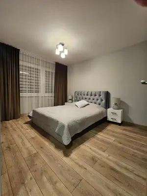 a bedroom with a bed and a wooden floor at Pleasant stay 1-bedroom apartment in Šiauliai
