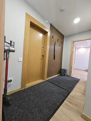 a hallway with a wooden door and a rug at Pleasant stay 1-bedroom apartment in Šiauliai