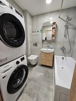 a bathroom with a washing machine and a sink at Pleasant stay 1-bedroom apartment in Šiauliai