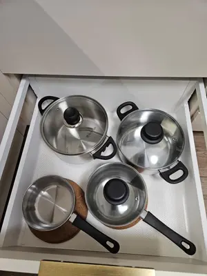 a group of four pots and pans on a stove at Pleasant stay 1-bedroom apartment in Šiauliai