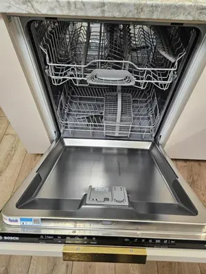 an open dishwasher with a laptop in it at Pleasant stay 1-bedroom apartment in Šiauliai