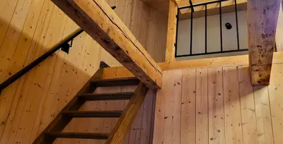 a wooden staircase in a room with a wooden wall at Inovatorių slėnis/ Innovators' valley in Antalieptė