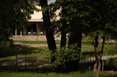 a house in the background with trees in the foreground at Inovatorių slėnis/ Innovators' valley in Antalieptė