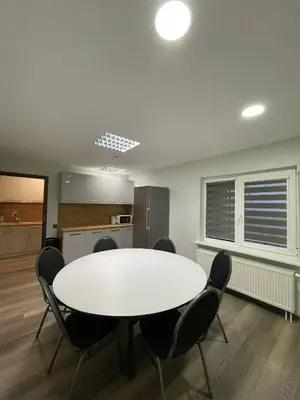 a dining room with a white table and chairs at Vaižganto Namas House for rent in Raseiniai