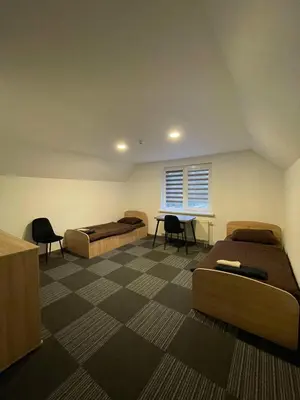 a room with two beds and a table and chairs at Vaižganto Namas House for rent in Raseiniai