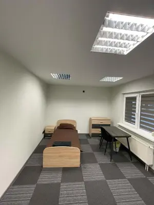 a room with two beds and a table in it at Vaižganto Namas House for rent in Raseiniai