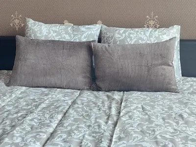 a bed with two pillows and a white comforter at R&M apartments in Kaunas