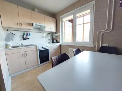 a kitchen with a white counter top and a table at R&M apartments in Kaunas