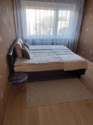 a bed sitting in a room with a window at R&M apartments in Kaunas
