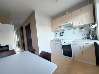 a small kitchen with a white table and a table and chairs at R&M apartments in Kaunas