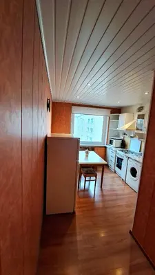 a kitchen with a table and a refrigerator in it at Apartment Ramune in Šiauliai