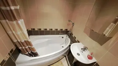 a bathroom with a white tub and a sink at Apartment Ramune in Šiauliai