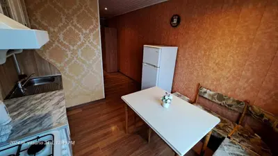 a small kitchen with a white table and a refrigerator at Apartment Ramune in Šiauliai
