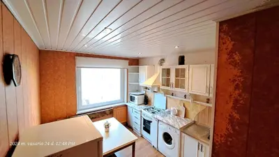 a kitchen with white cabinets and a window at Apartment Ramune in Šiauliai