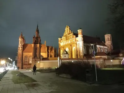 a large cathedral at night with a person walking in front at MAIRONIO gt 19-7 in Vilnius