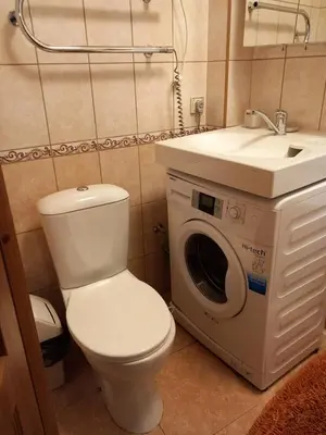 a bathroom with a toilet and a sink and a washing machine at MAIRONIO gt 19-7 in Vilnius