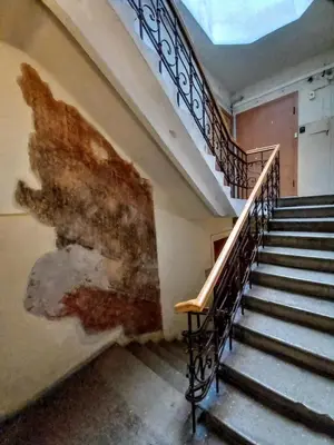 an old building with stairs and a painting on the wall at MAIRONIO gt 19-7 in Vilnius
