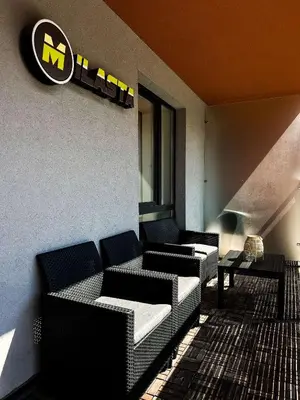 a lobby with couches and a sign on a wall at Milastos apartamentai in Birštonas