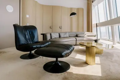 a living room with a leather chair and a couch at Vilnius TV Tower Apartments DEBESYS in Vilnius
