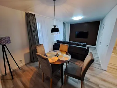 a living room with a table and chairs and a couch at Jaukūs apartamentai centre A. J. Greimo g. in Šiauliai