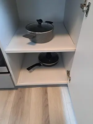a kitchen shelf with a pot and pan on it at Jaukūs apartamentai centre A. J. Greimo g. in Šiauliai