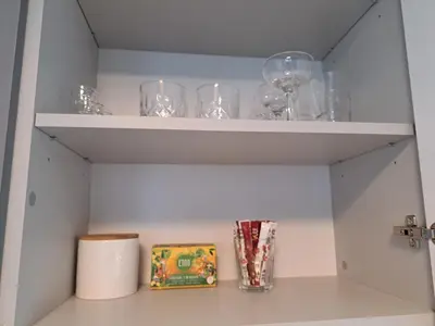 a shelf with glasses and a box on it at Jaukūs apartamentai centre A. J. Greimo g. in Šiauliai